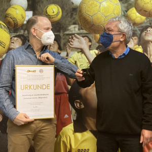 Der VdSBB-Vorsitzende Hanns Ostermann (rechts) bei der Überreichung des Goldenen Bandes an streetfootballworld-Mitbegründer Johannes Axster (Foto: VdSBB)